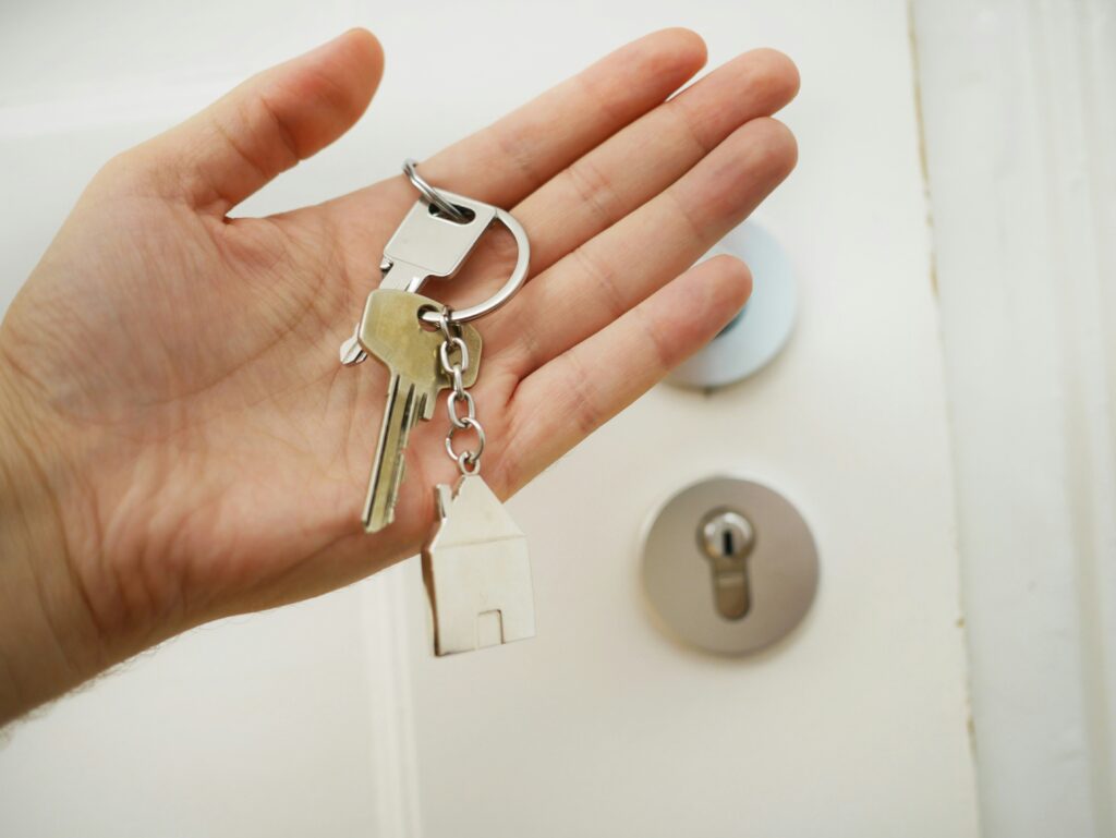 A hand holding a house keychain