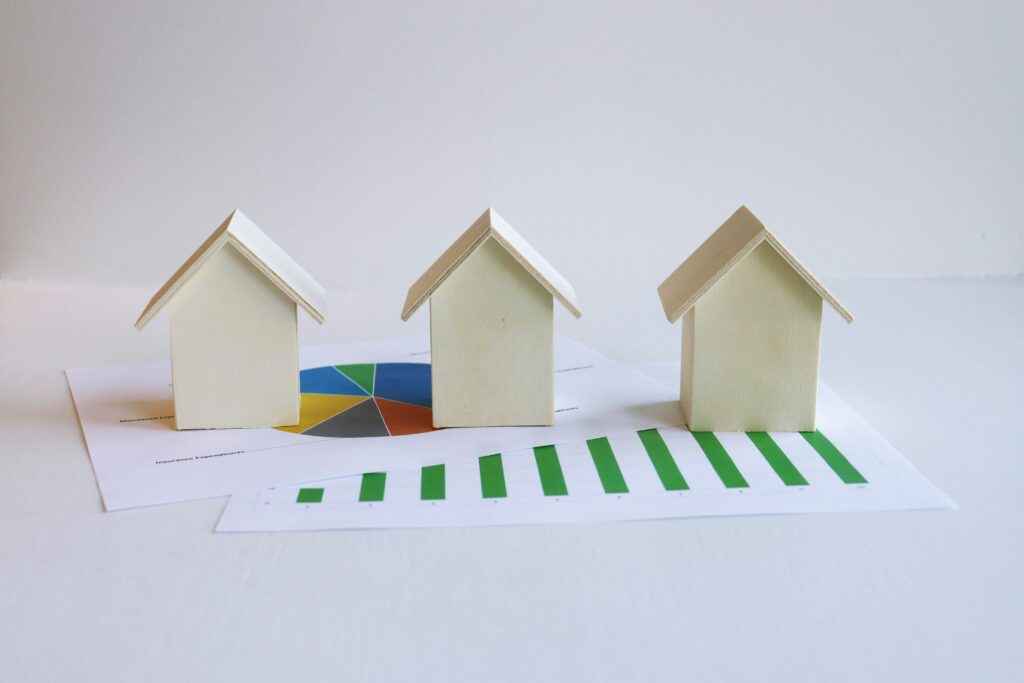 Three miniature houses placed on a mortgage loan data sheet