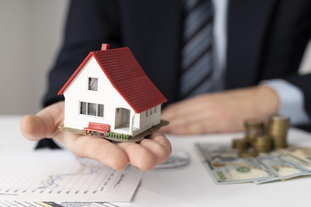 A man holding a small house replica