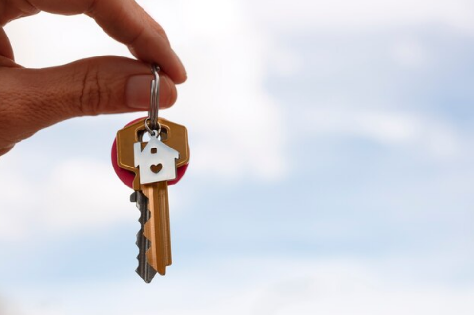 A guy holding his key to his mortgage loan house