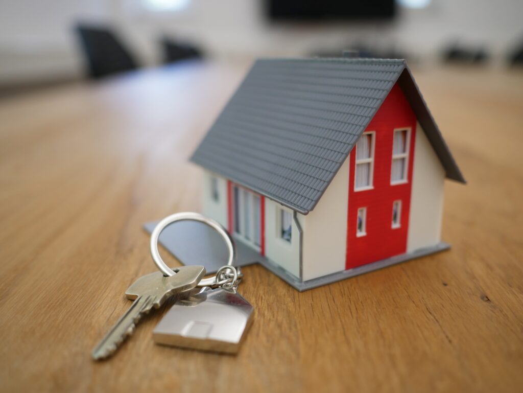 A miniature model house with keys for a home loan plan
