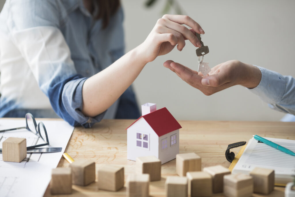 A woman transfering-the keys to a homeowner